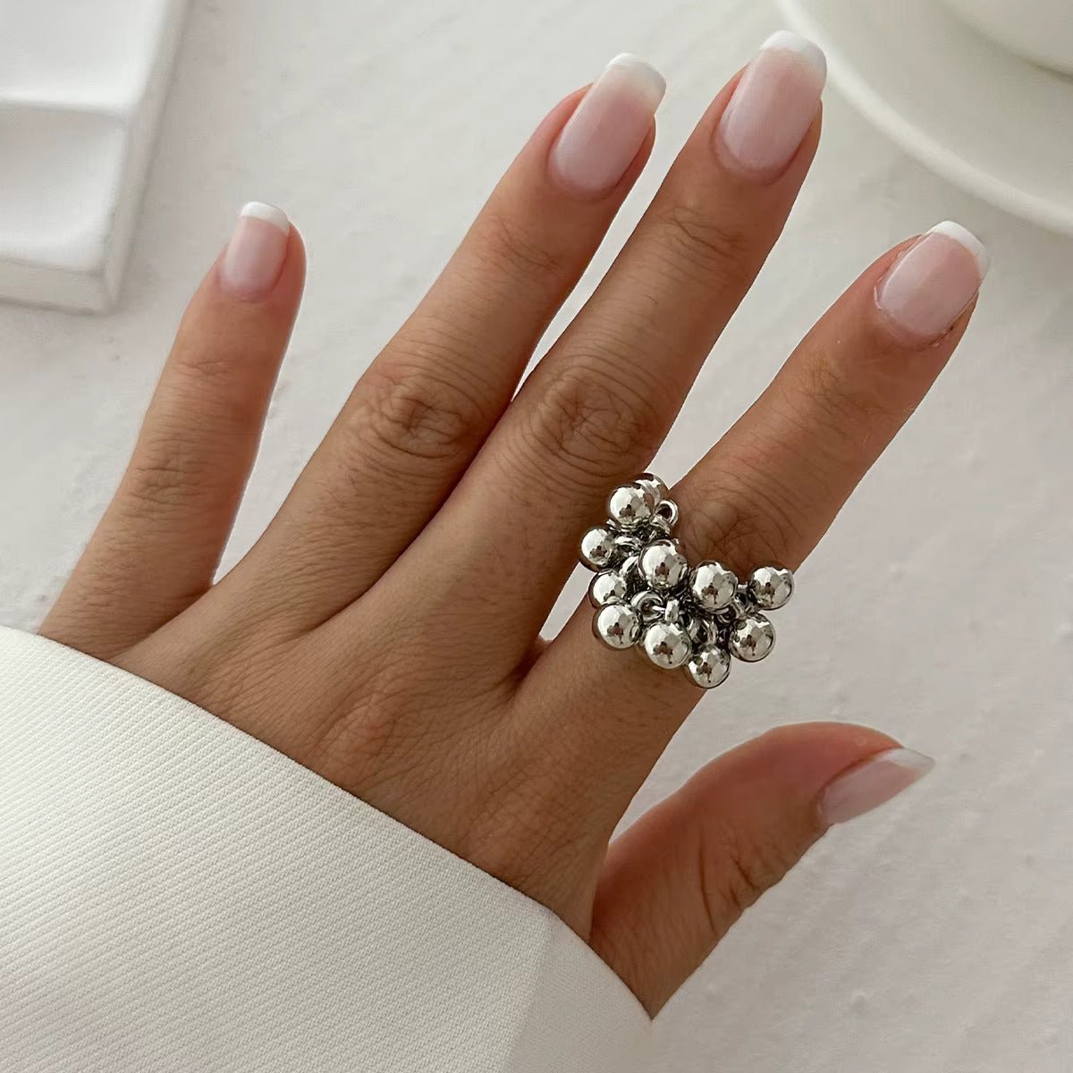 Bague Eos argentée portée sur une main, avec un design moderne et minimaliste. Un anneau élégant et polyvalent pour un look sophistiqué.
